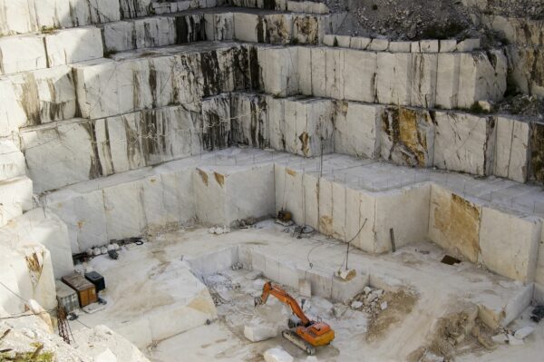 An open quarry of white marble with bulldozer, in Carrara, Tuscany, Italy